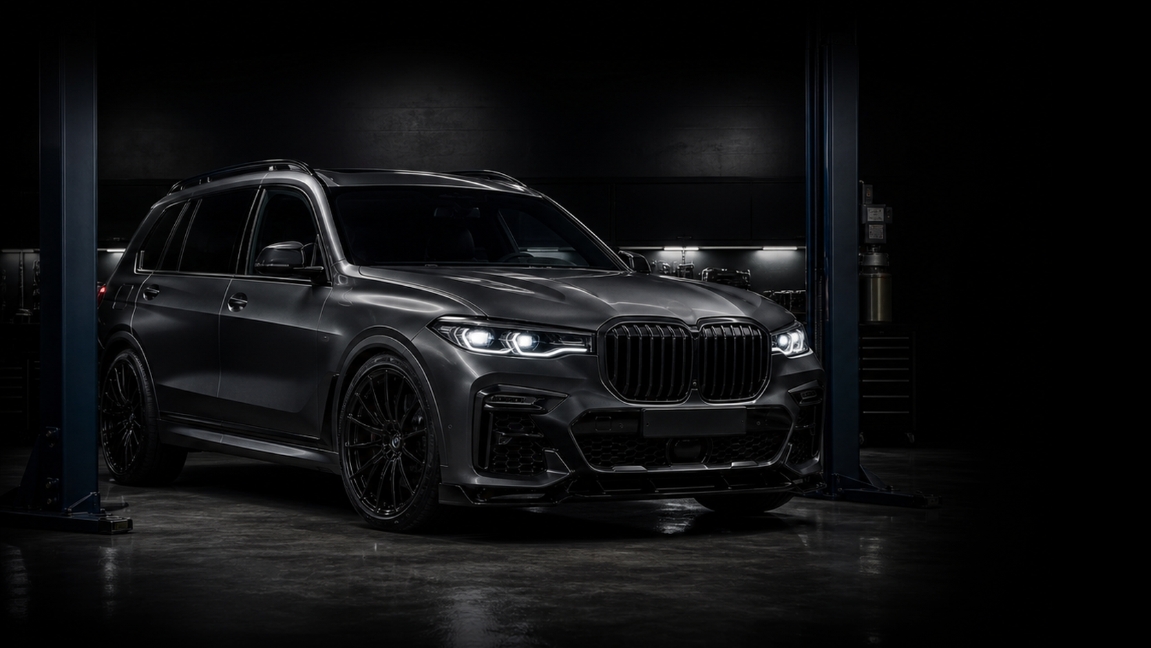 Dark BMW SUV in a premium mechanic shop bay