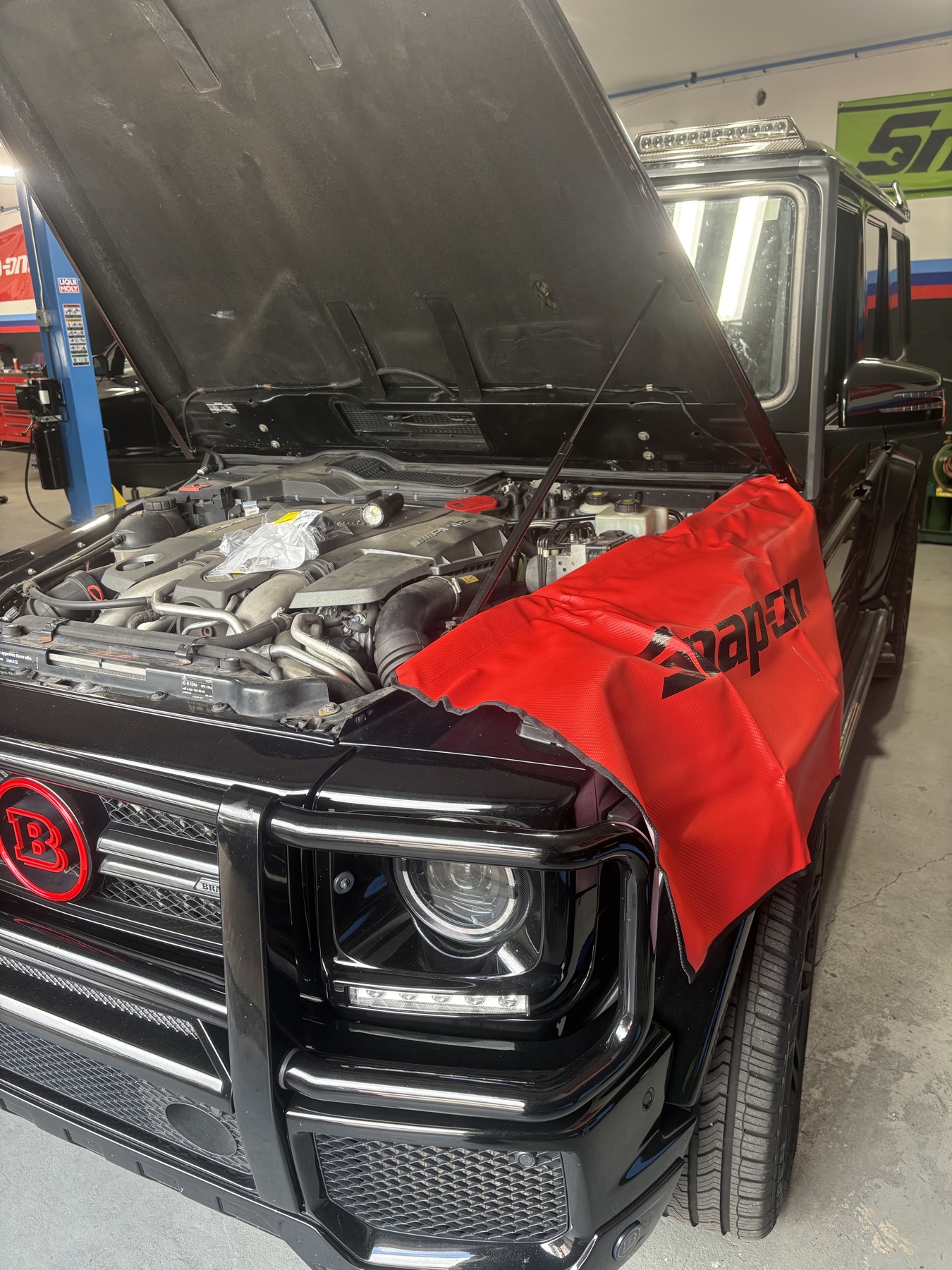 Open engine bay of a black Brabus G-Wagon protected for service