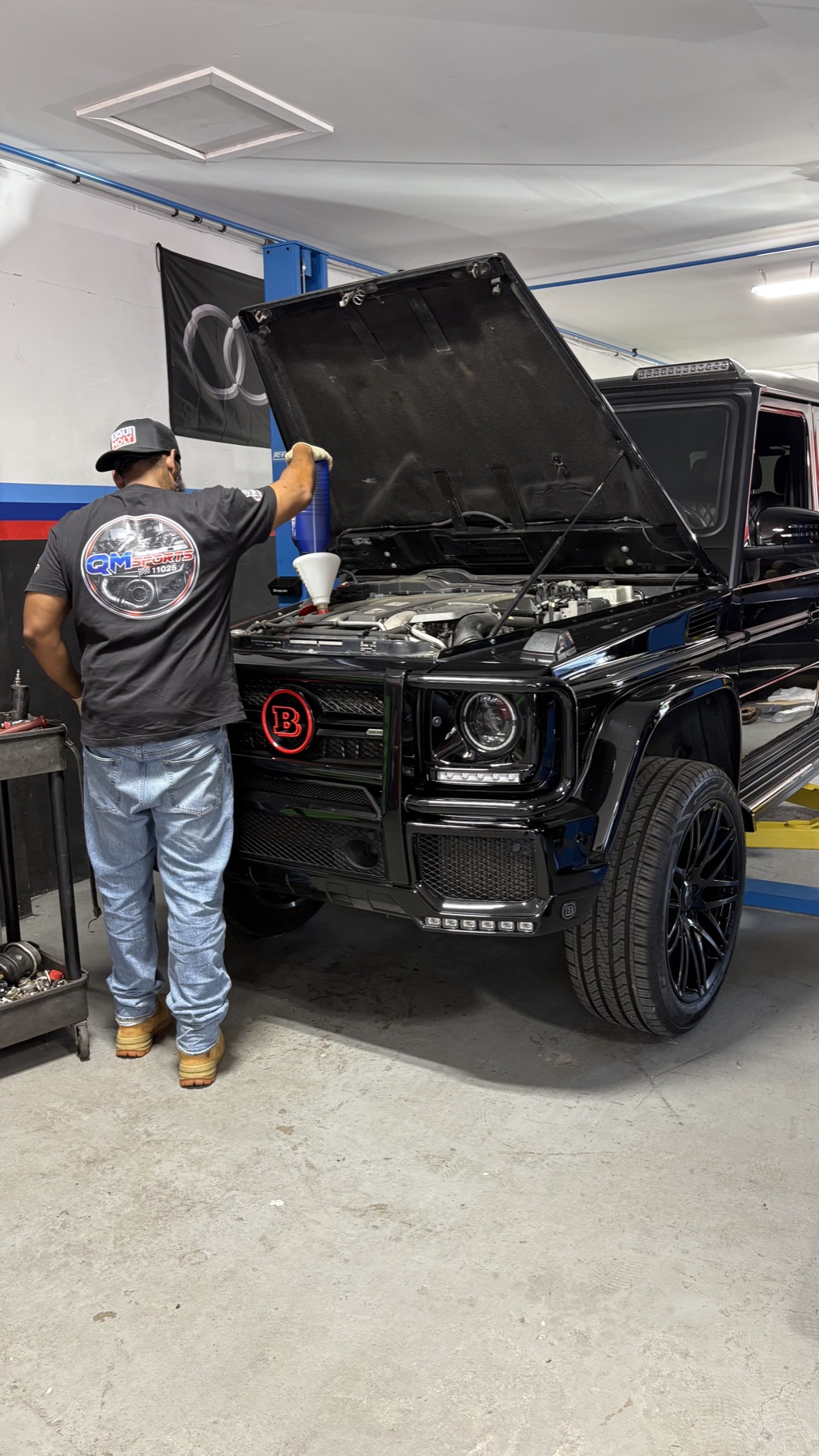 Technician servicing a black Brabus G-Wagon at Quazie Motor Sports