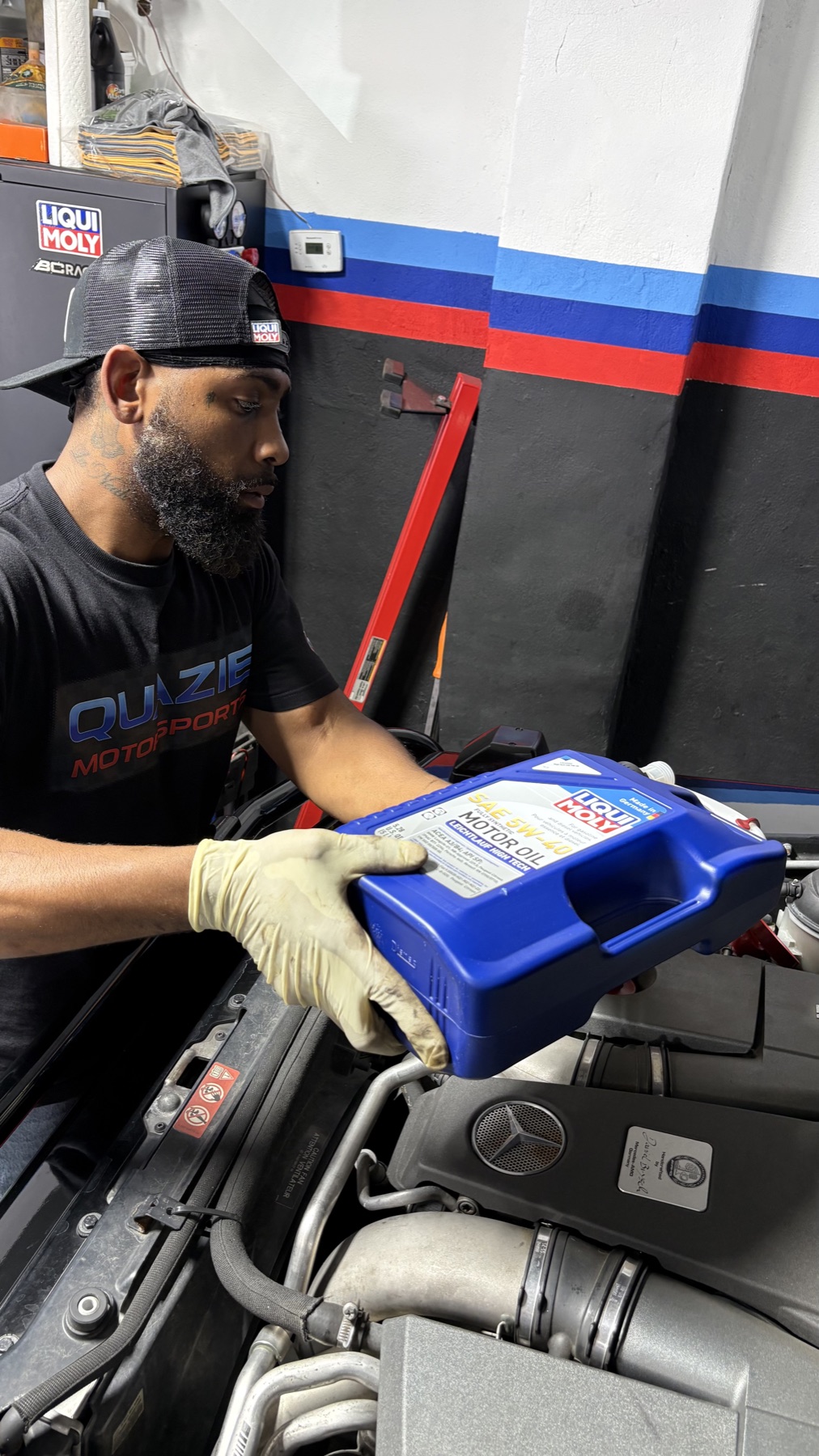 Technician adding Liqui Moly oil to a Mercedes-Benz engine