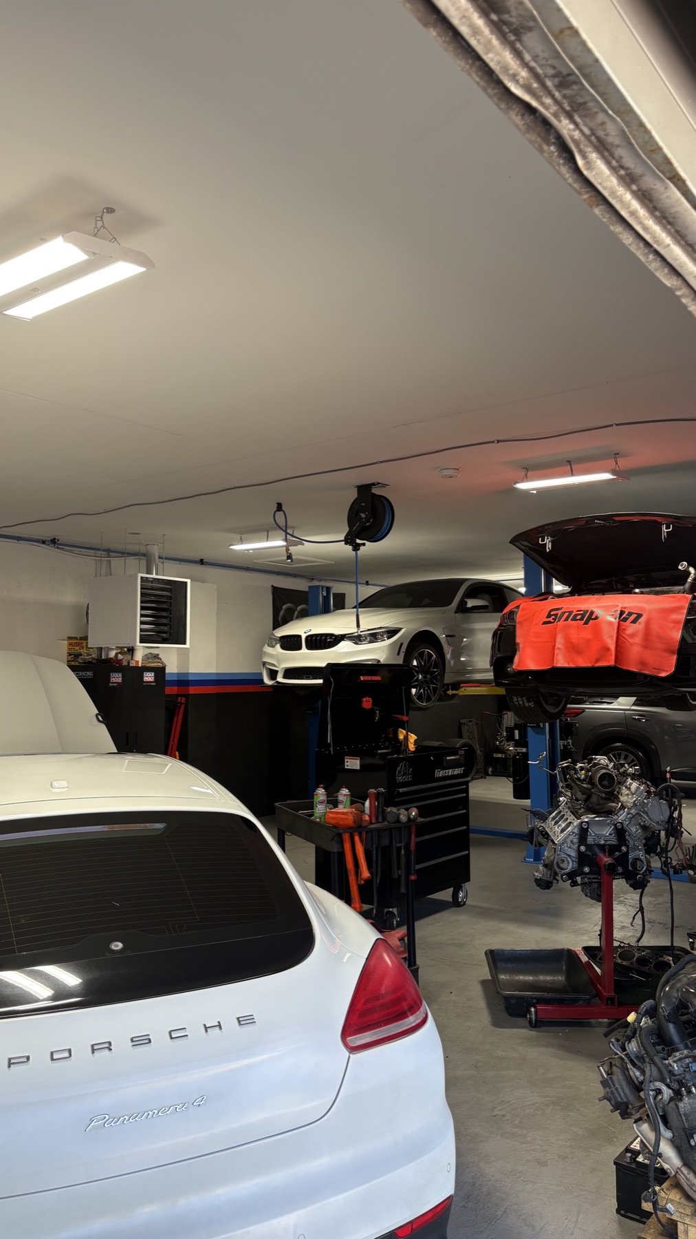 Porsche Panamera, BMW on a lift, and engine work in the shop