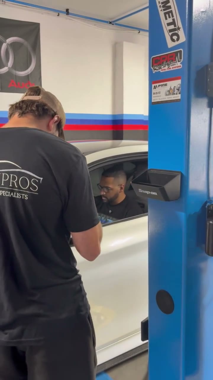 Technicians working beside a vehicle inside Quazie Motor Sports